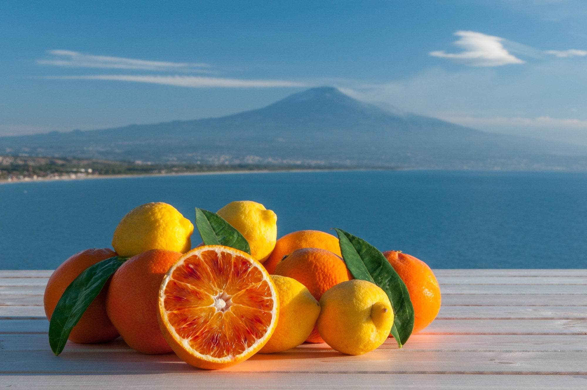 Sicilien. Oranges and lemons, blue sea, Mount Etna and clouds in the background